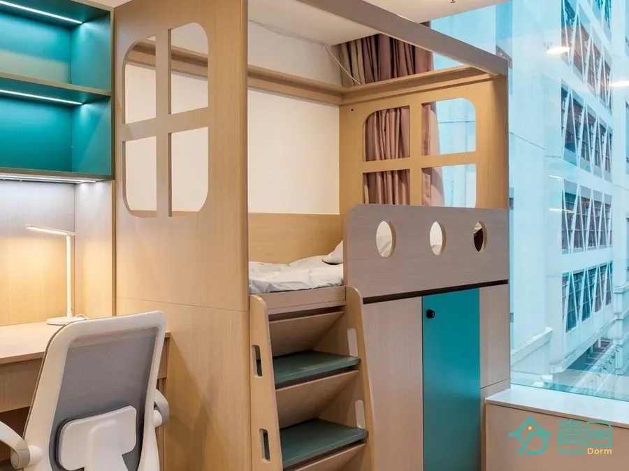 Bedroom area at the Sheung Wan Dorm (Youth Dorm) with bunk beds, desk and a city-facing window
