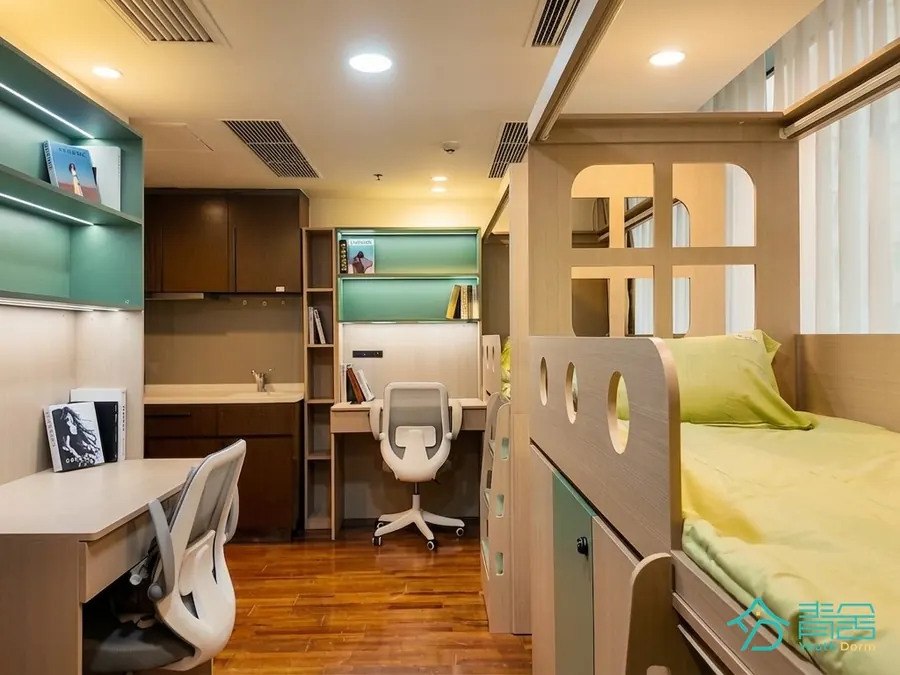 Furnished room at the Sheung Wan Dorm (Youth Dorm) with bunk beds, desks, shelving and wood flooring